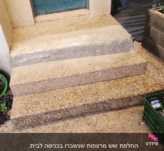 מדרגות בטון עם סימני שיפוץ ודלת כחולה